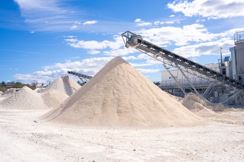 Stockpile of processed aggregate beside a conveyor