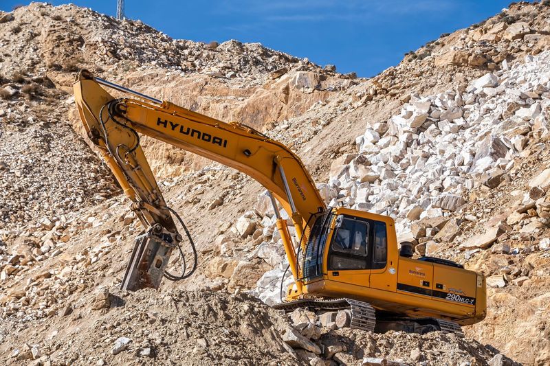 Excavator loading rock in a quarry